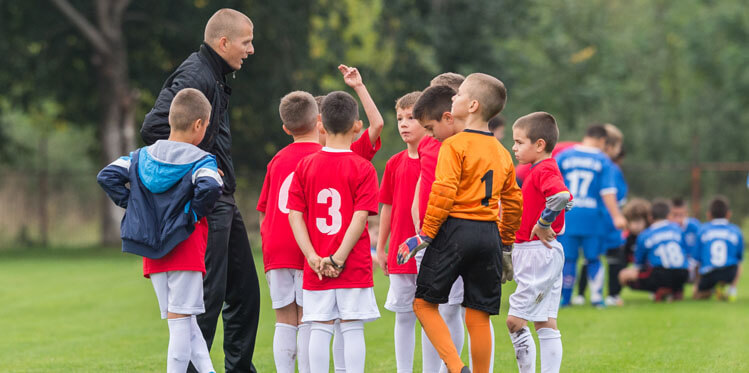 boys talking to football coach